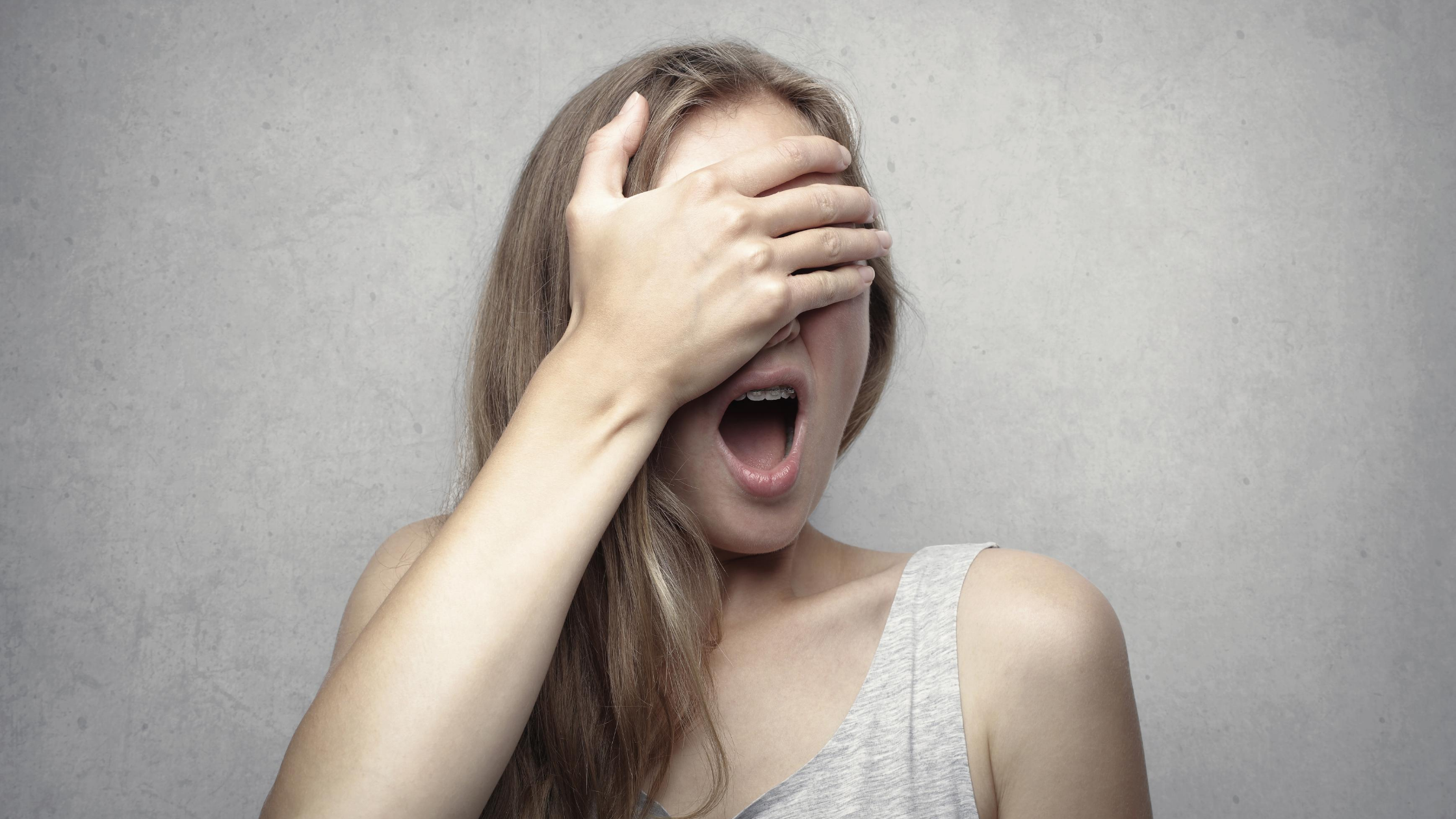 Vrouw met hand voor ogen die angstig is